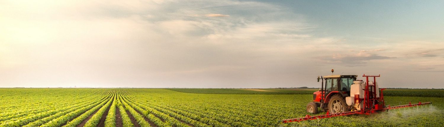 Tractor spraying glyphosate at soy bean field